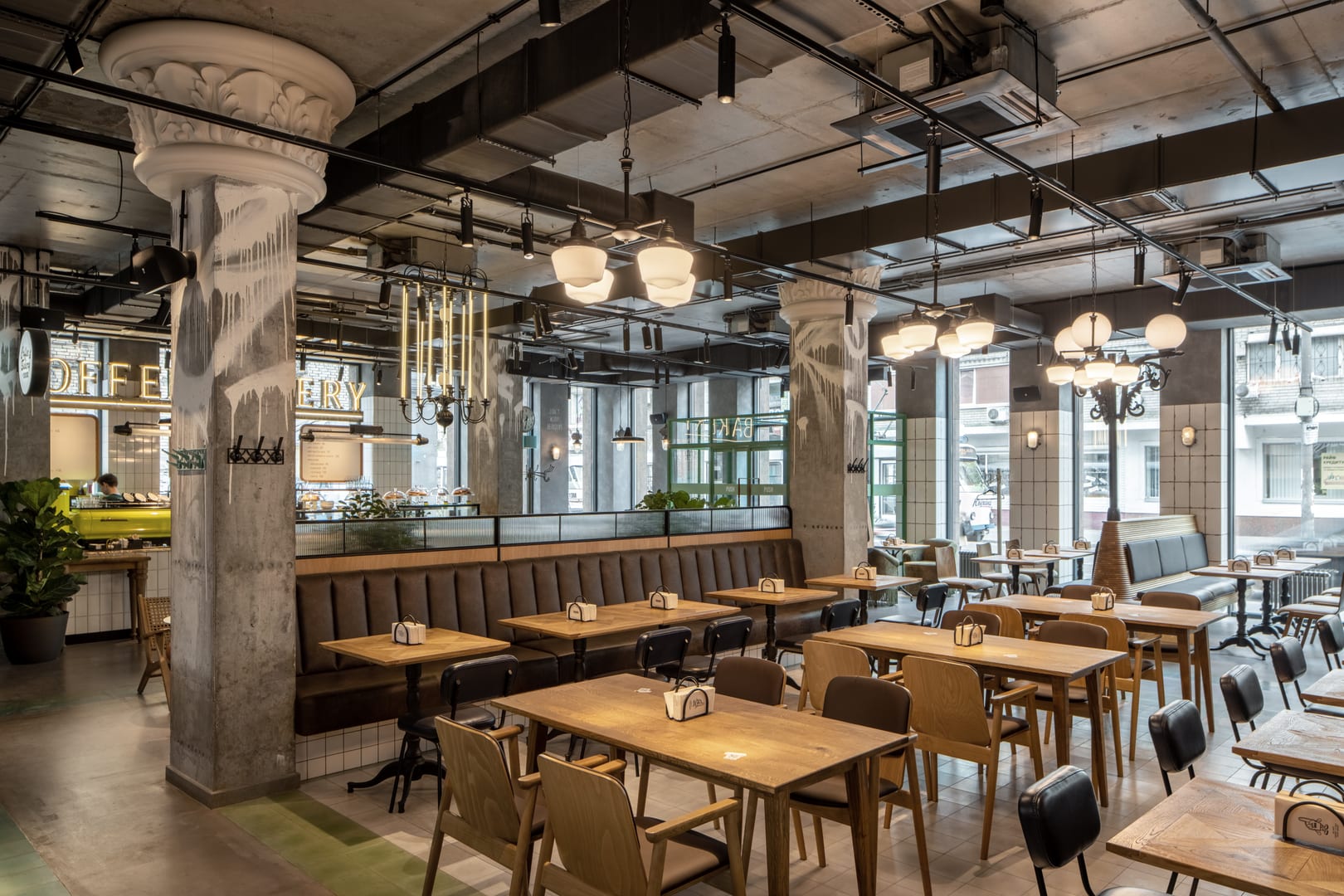 Restauracja w stylu loft — stoły dębowe, betonowe kolumny, vintage oświetlenie